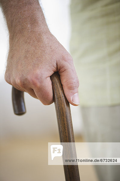 Close-up of senior man's hand on cane