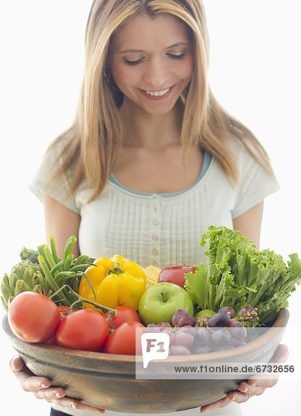 Woman holding bowl of organic fruit and vegetables