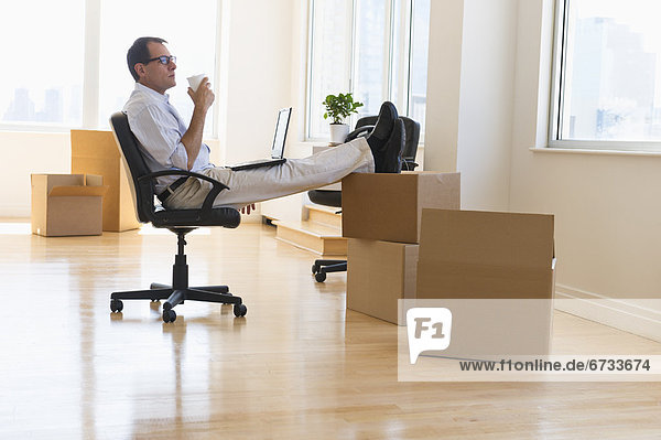 Businessman using laptop in new office
