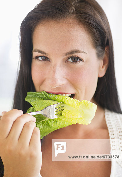Portrait of woman eating lettuce
