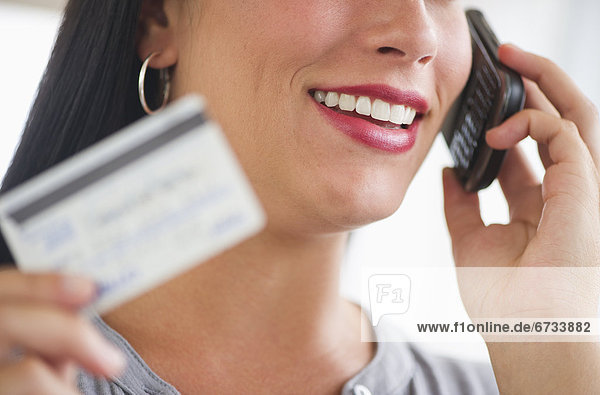 Woman holding credit card and phone