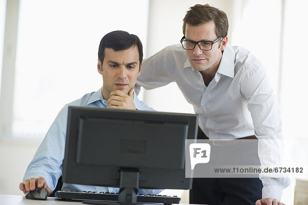 Two businessmen looking at computer