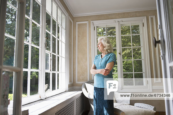 Senior woman looking through window