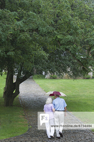 Seniorenpaar geht in Park spazieren