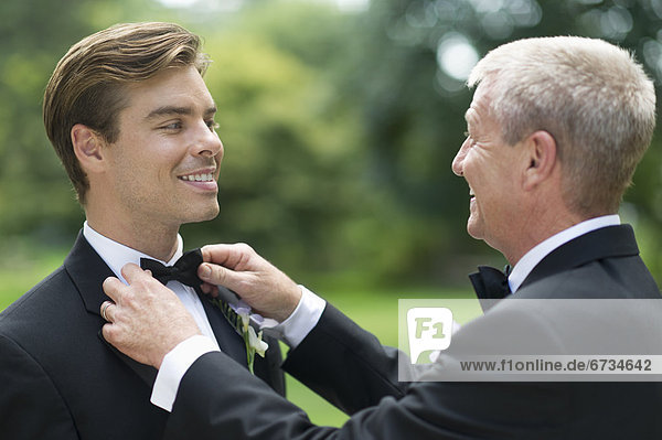Father adjusting groom's bow tie