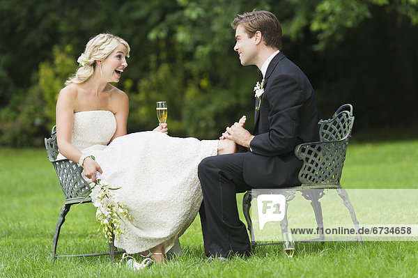 Newly wed couple sitting  groom massaging bride's feet