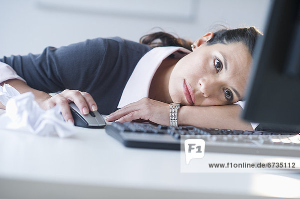 Businesswoman in front of computer  looking tired