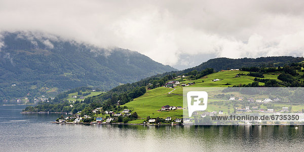 'Houses On A Hill Along The Water's Edge Of Hardangerfjord