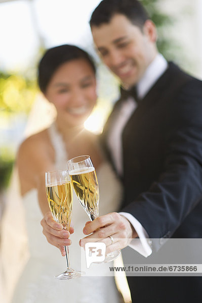 Braut und Bräutigam toasting with champagne