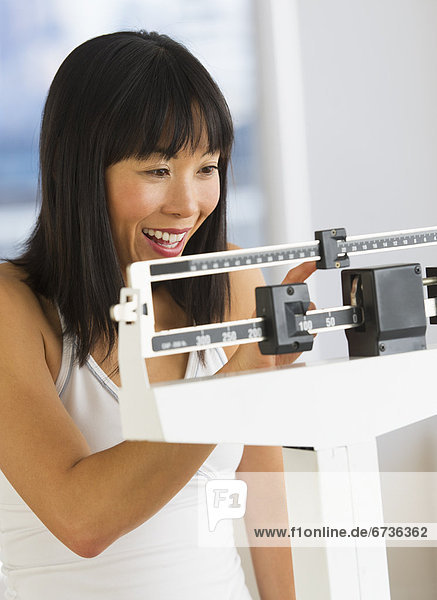 Smiling woman checking her weight