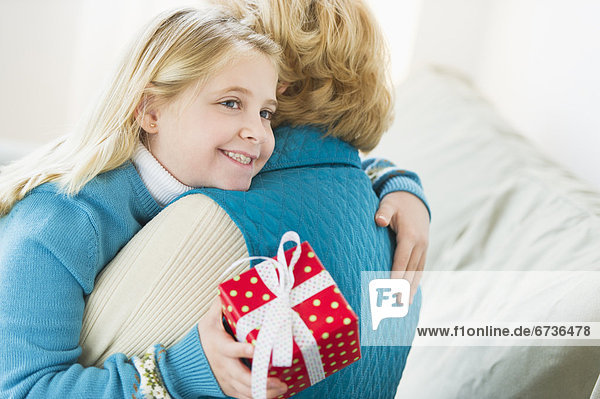 Geschenk  umarmen  halten  Enkeltochter  Großmutter  5-9 Jahre  5 bis 9 Jahre