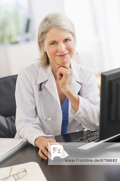 Portrait of senior female doctor working in her office