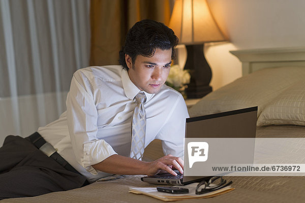 Businessman working on laptop in hotel room