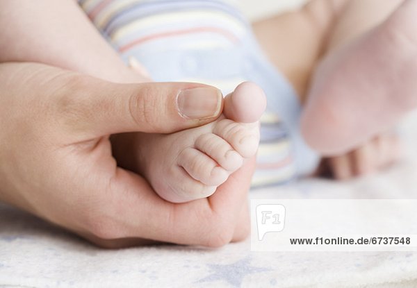 Close up of babyÕs foot in motherÕs hand