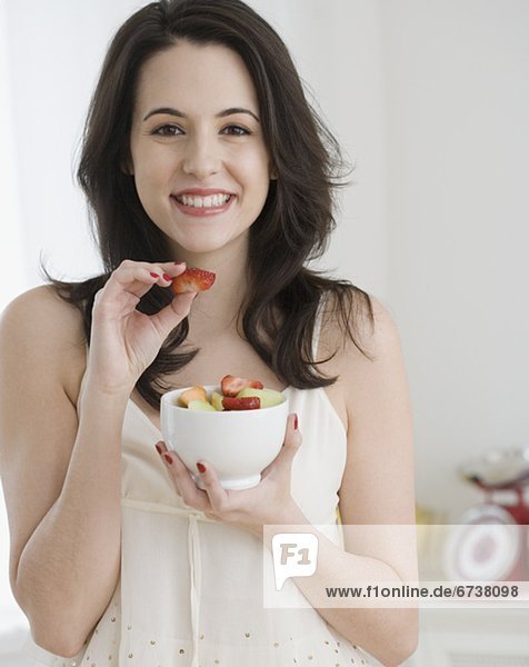 Portrait of woman eating fruit salad