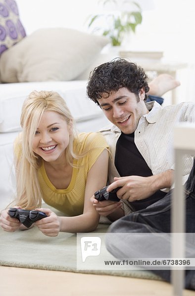 Couple playing video games on floor