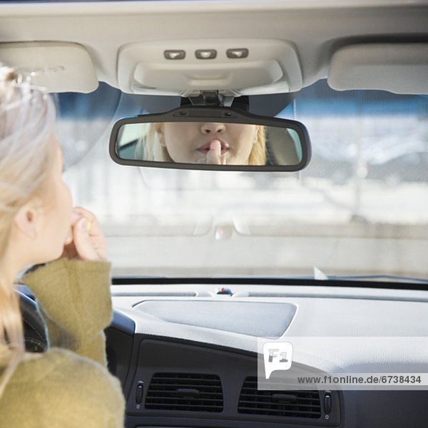 eincremen  verteilen  Frau  Auto  Lippenstift  Rückansicht  Ansicht  auftragen  Spiegel