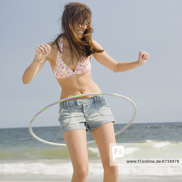 Young woman playing with hula hoop