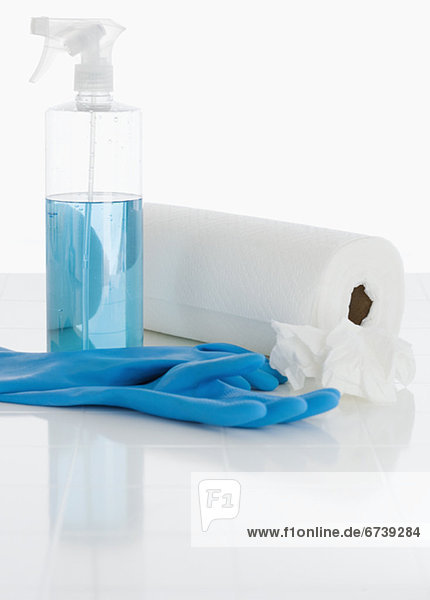 Rubber gloves and cleaning solution next to paper towels