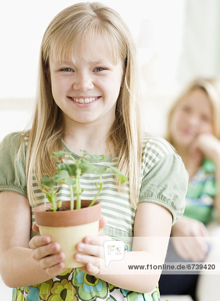 Mädchen hält Getopfte Pflanzen