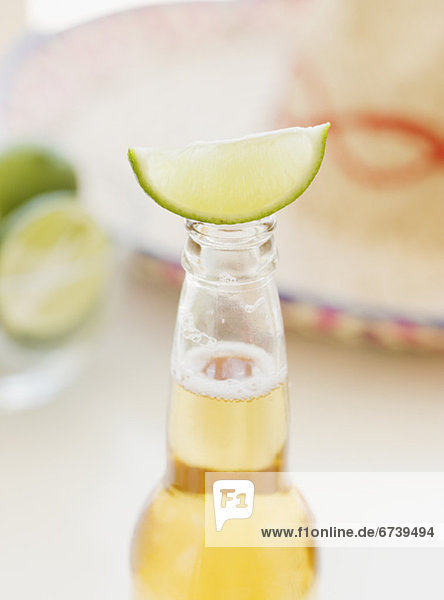 Close up of lime balancing on beer bottle