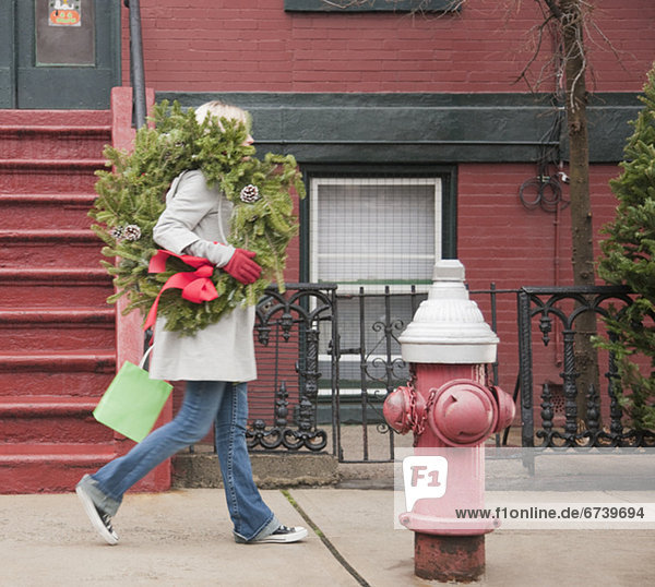 Städtisches Motiv  Städtische Motive  Straßenszene  Straßenszene  Frau  tragen  Straße  Weihnachten  Blumenkranz  Kranz