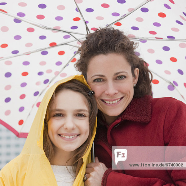 Mother and daughter (10-12 years) under umbrella  portrait