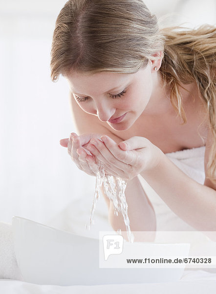 Eine Frau wäscht ihr Gesicht