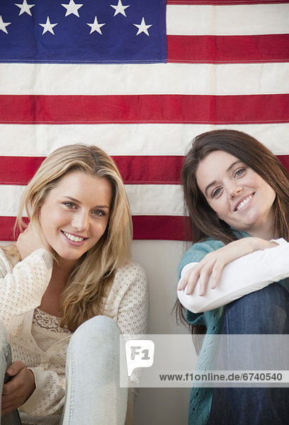 Friends sitting in front of American flag