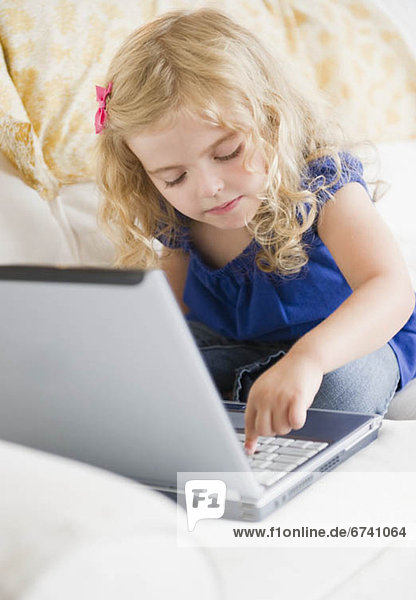 Girl (4-5) using laptop