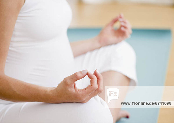 Junge schwangere Frau meditieren