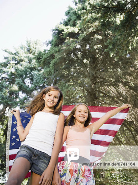 USA  New York  Two girls (10-11  10-11) playing with American flag