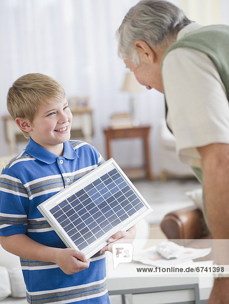 zeigen  Enkelsohn  Großvater  Sonnenkollektor  Sonnenenergie  5-9 Jahre  5 bis 9 Jahre  Tisch