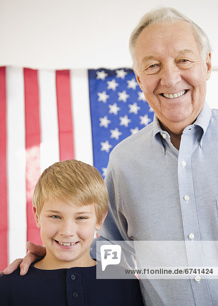 Portrait of grandfather with grandson (8-9) with American flag