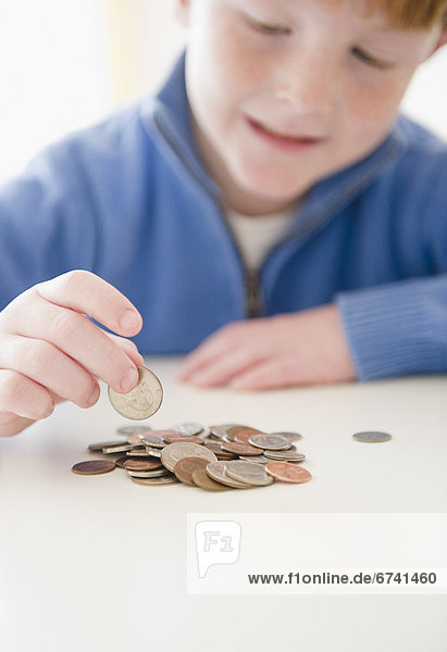 Portrait of boy (8-9) counting coins