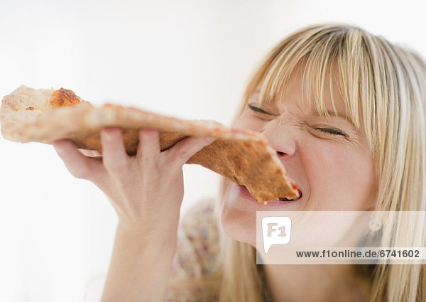 Junge Frau beim Pizza essen