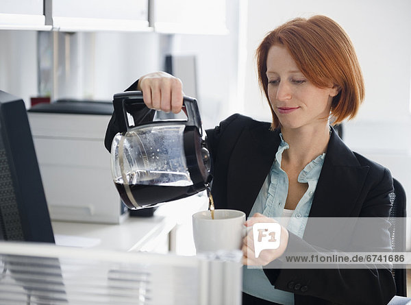 USA  New Jersey  Jersey City  businesswoman pouring coffee