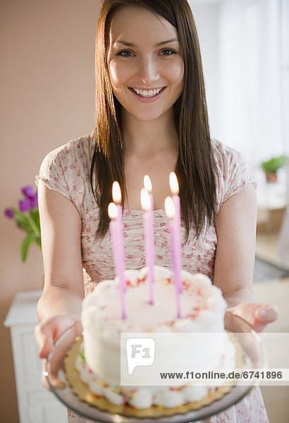junge Frau hält Geburtstagstorte