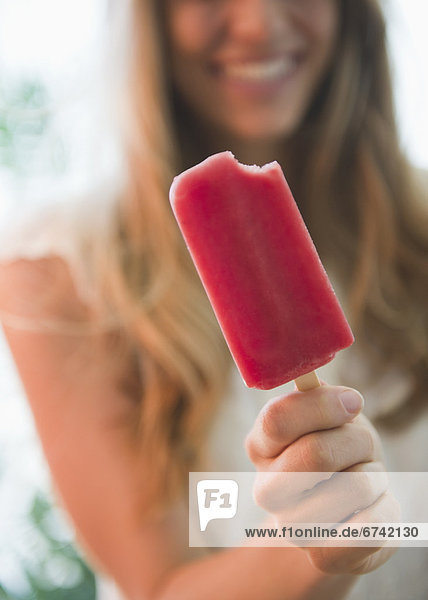 Close up of woman holding popsicle