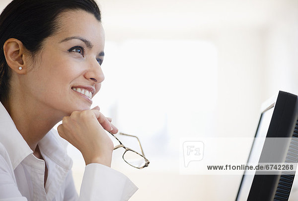 Businesswoman daydreaming at desk in office