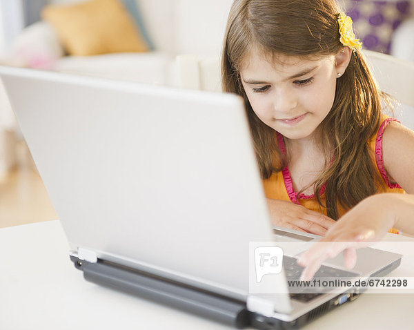 Girl ( 6-7) using laptop