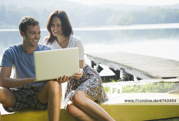 Roaring Brook Lake  Couple using laptop by lake