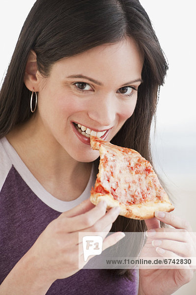 Portrait of woman eating pizza slice
