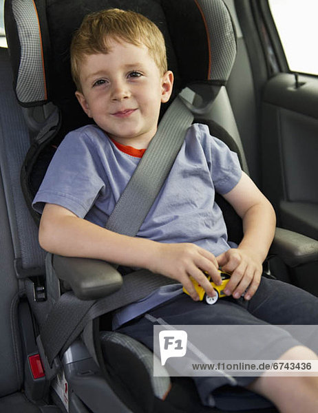 Young boy sitting in his car seat