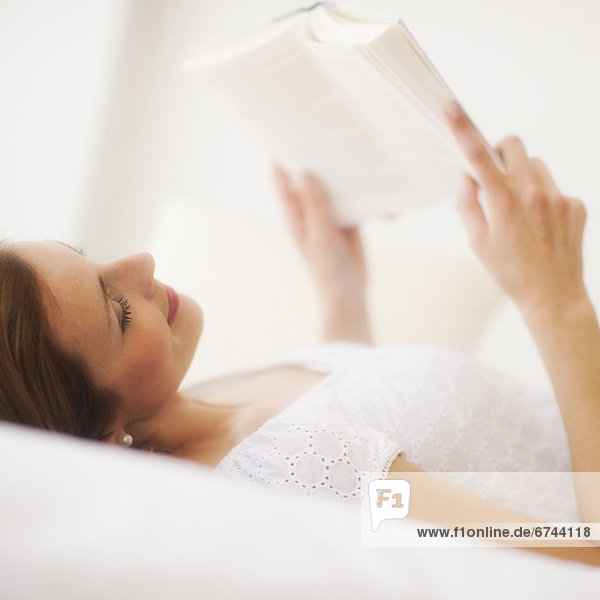 Sensual portrait of young woman reading book