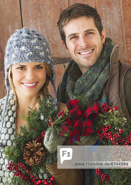 Couple holding christmas wreath