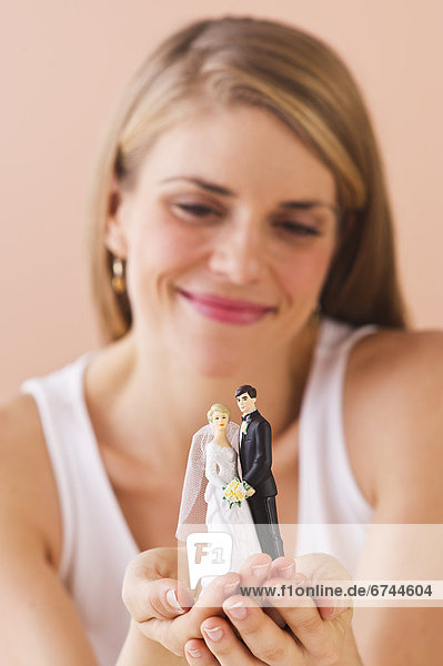 Young woman holding wedding figurine
