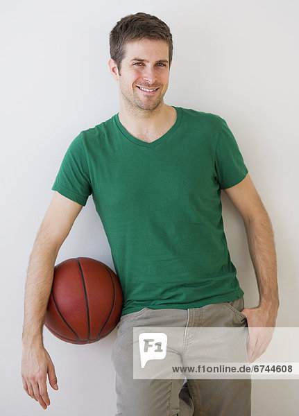 Young man standing with basket ball