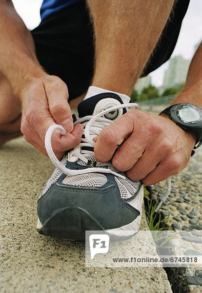 Man Tying Up Laces on Sneaker
