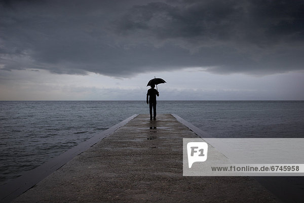 Man with Umbrella Standing on Pier  Woodbine Beach  Toronto  Ontario